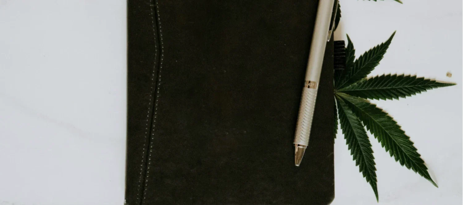 Notizheft mit Stift und Cannabisblatt