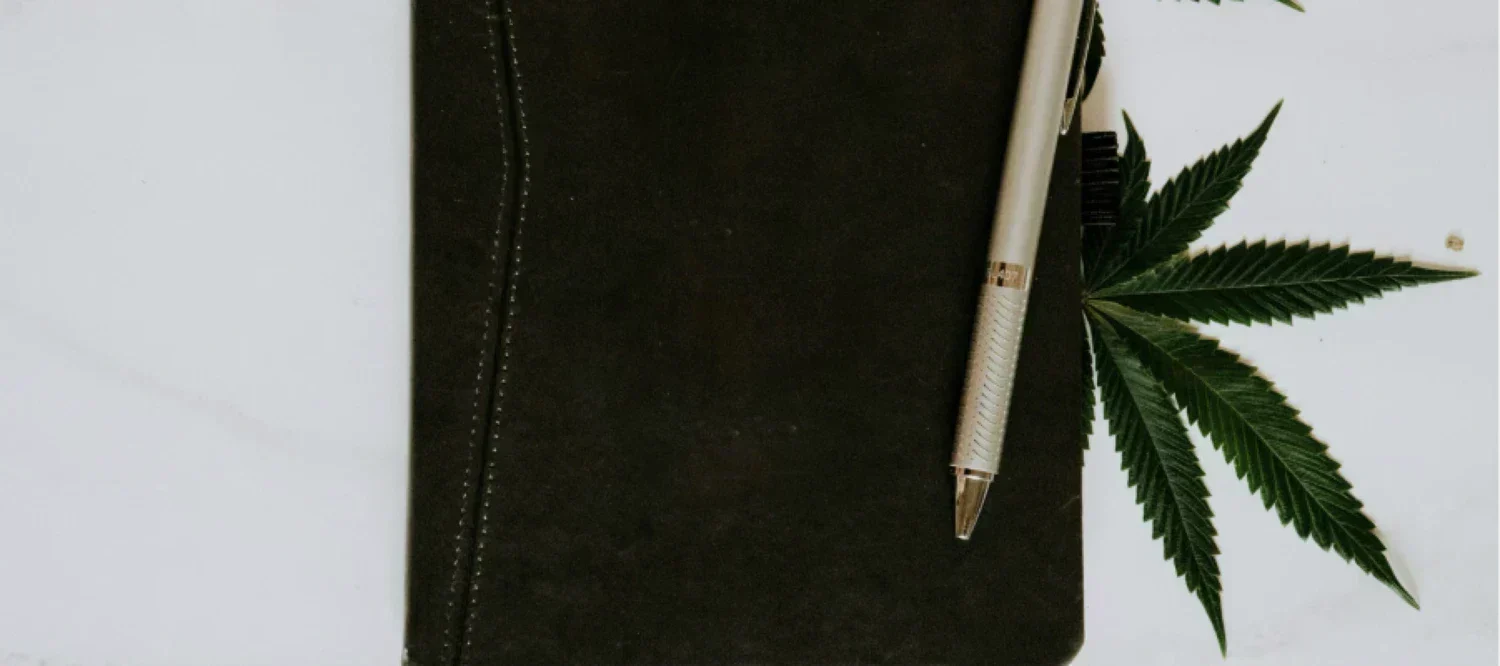 Notizheft mit Stift und Cannabisblatt